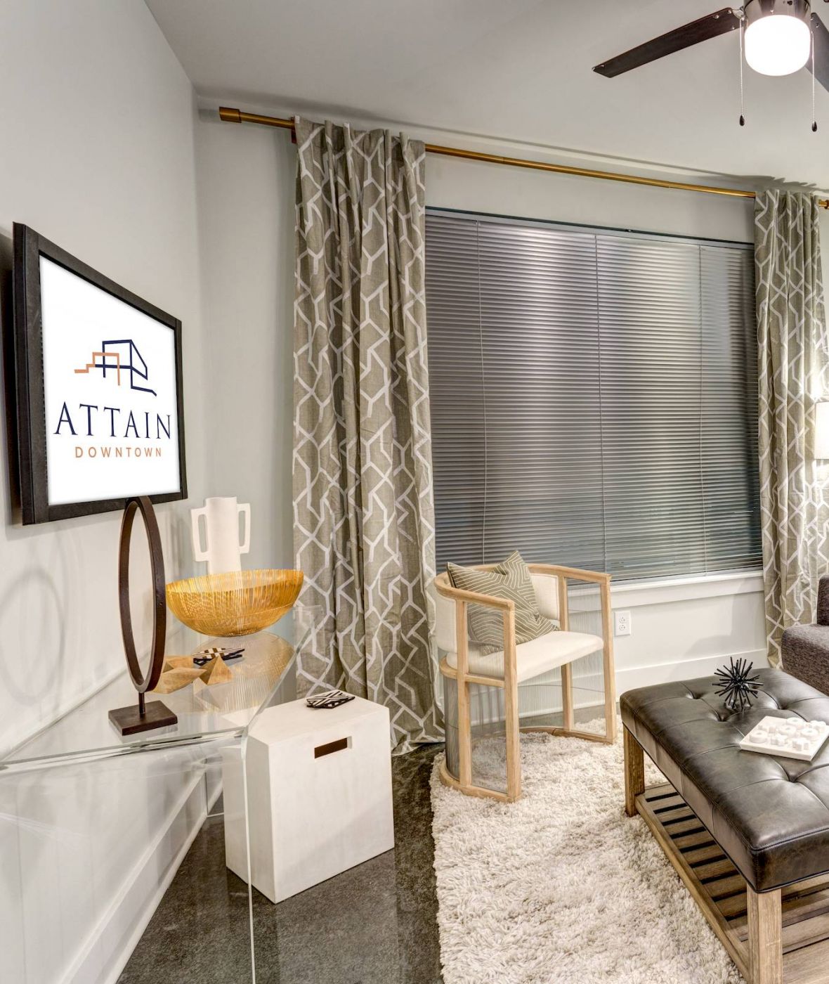 Attain Downtown apartment homes with Modern living room with a gray sofa, art on the walls, and a TV displaying "Attain Downtown.