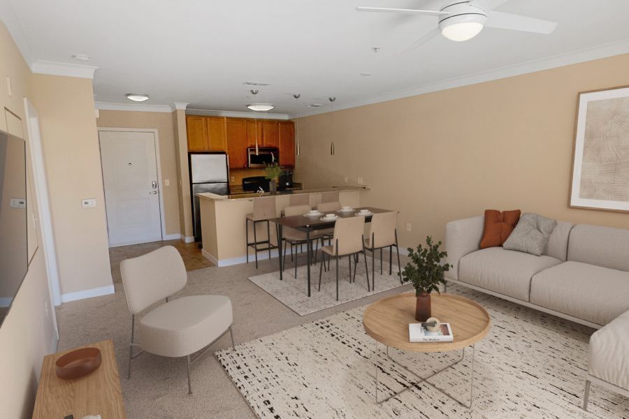 Attain Downtown East apartment homes with A bright living room with beige walls, modern furniture, a ceiling fan, and an open kitchen in the background.